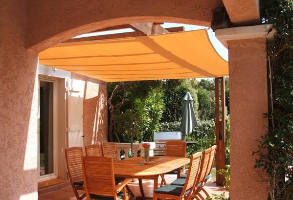 Vela ombreggiante traspirante sopra una terrazza con pergola