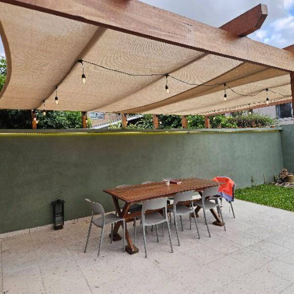 Vela ombreggiante Coolaroo sopra terrazza e giardino